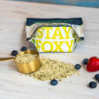 Hemp Hearts with a 'Stay Foxy' packaging on a wooden surface with berries