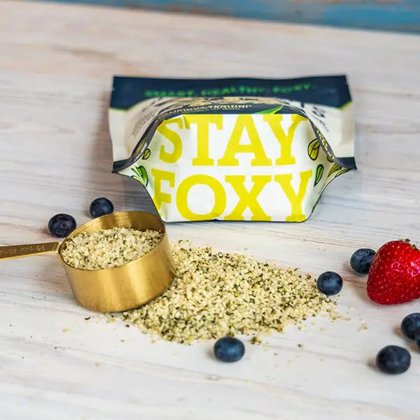 Hemp Hearts with a 'Stay Foxy' packaging on a wooden surface with berries